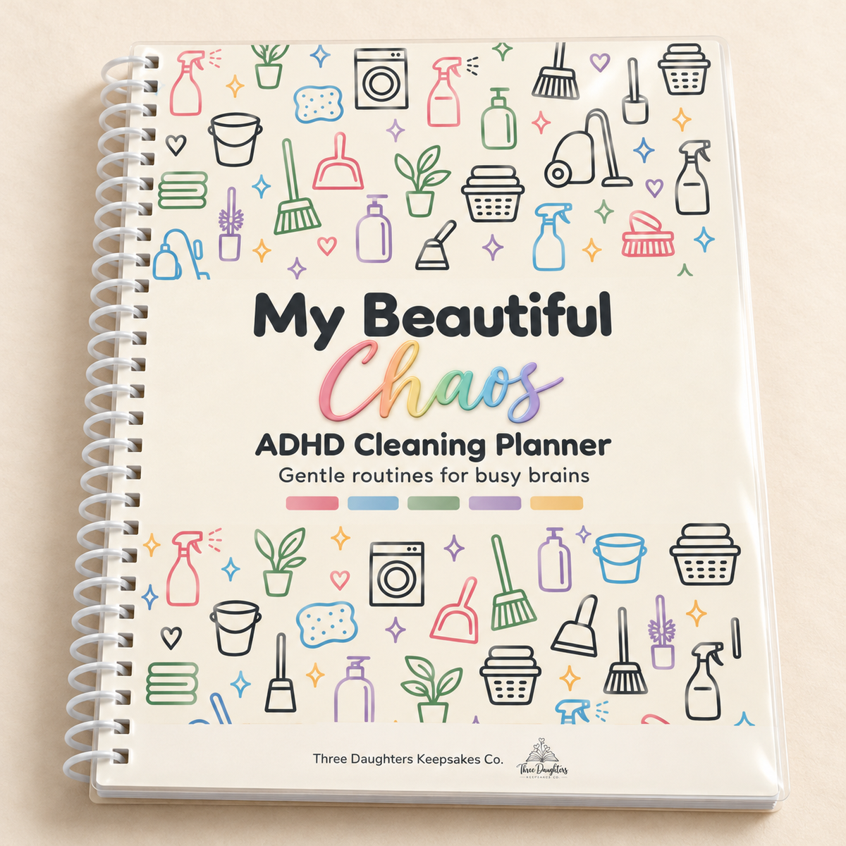 Spiral bound My Beautiful Chaos ADHD cleaning planner with a clear cover and pastel cleaning supply icons